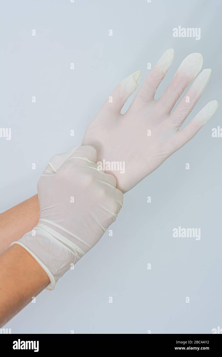 Manos de mujeres poniéndose guantes de látex Foto de stock