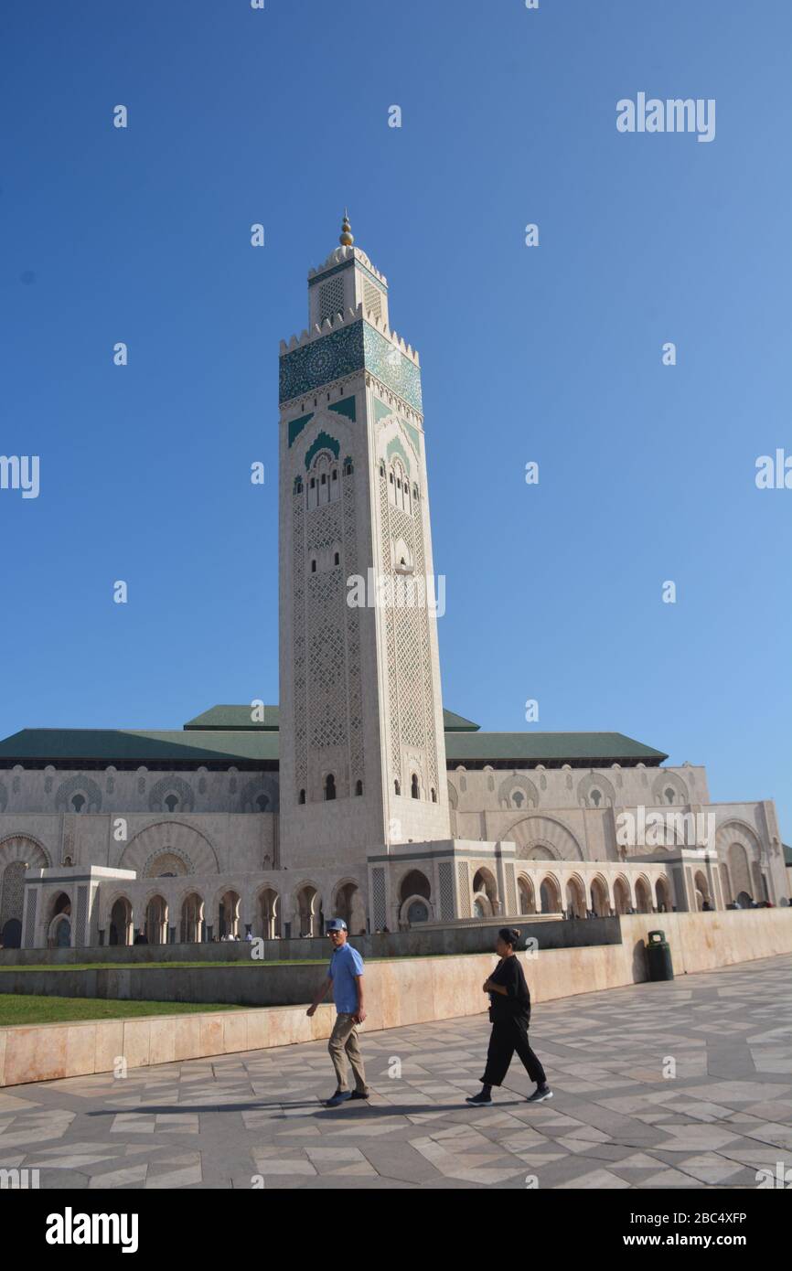 Espectacular foto exterior de la Mezquita Hassan II, Casablanca, Marruecos, mostrando el enorme tamaño del edificio en comparación con la gente. Foto de stock