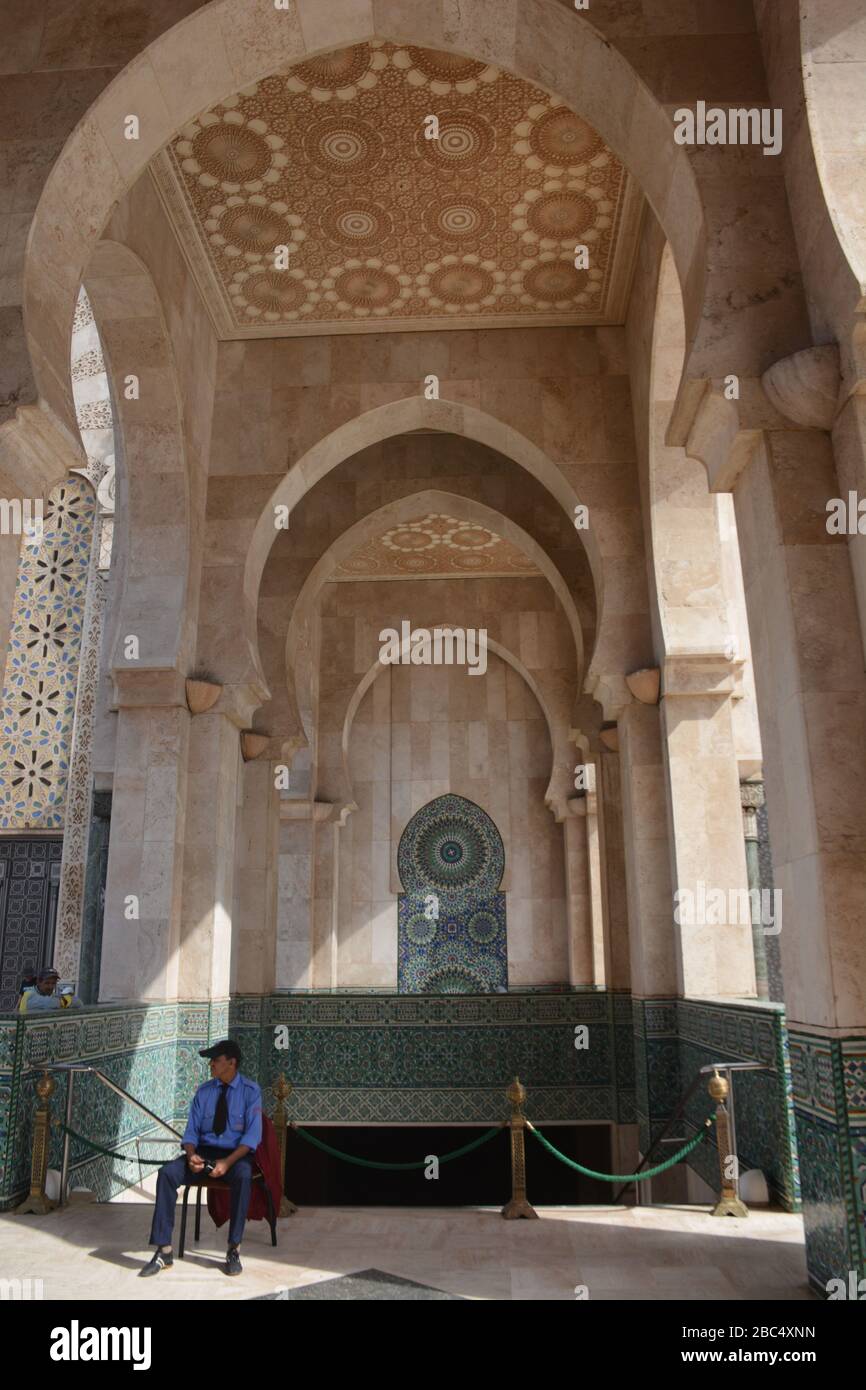 Un guardia de seguridad se encuentra junto a un punto de entrada y salida en la Mezquita Hassan II, Casablanca, Marruecos, construido a un costo de 585 millones de euros y abrió en 1993. Foto de stock