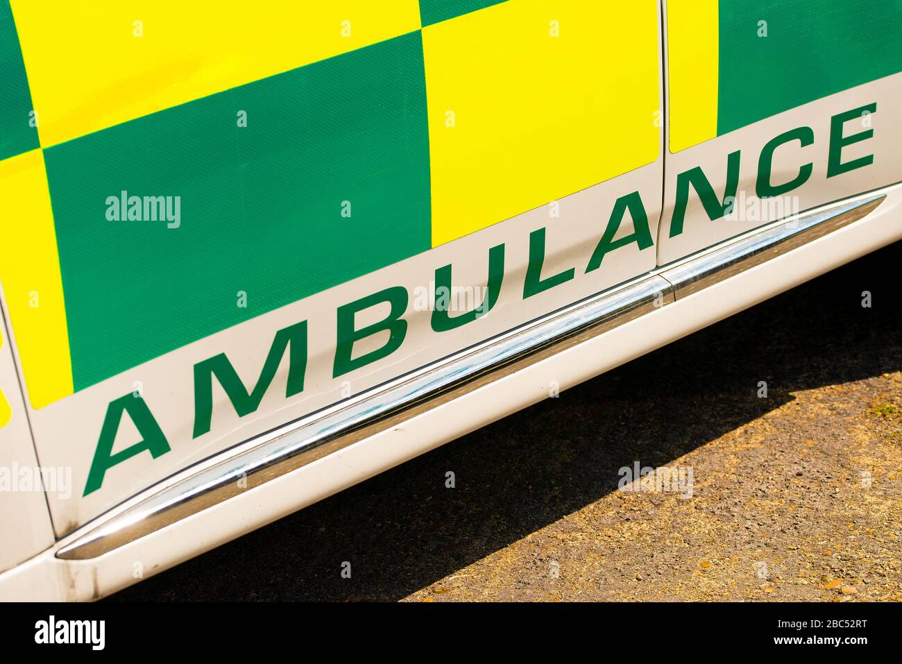 Vista en ángulo alto de la señal DE AMBULANCIA en vehículo médico de respuesta de emergencia NHS verde y amarillo de alta visibilidad. Foto de stock