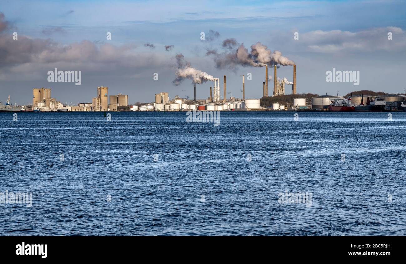 Zonas industriales en el borde del Limfjord que atraviesan el centro de Aalborg, Dinamarca. Chimeneas para fumar están en la fábrica de cemento de Portland. Foto de stock