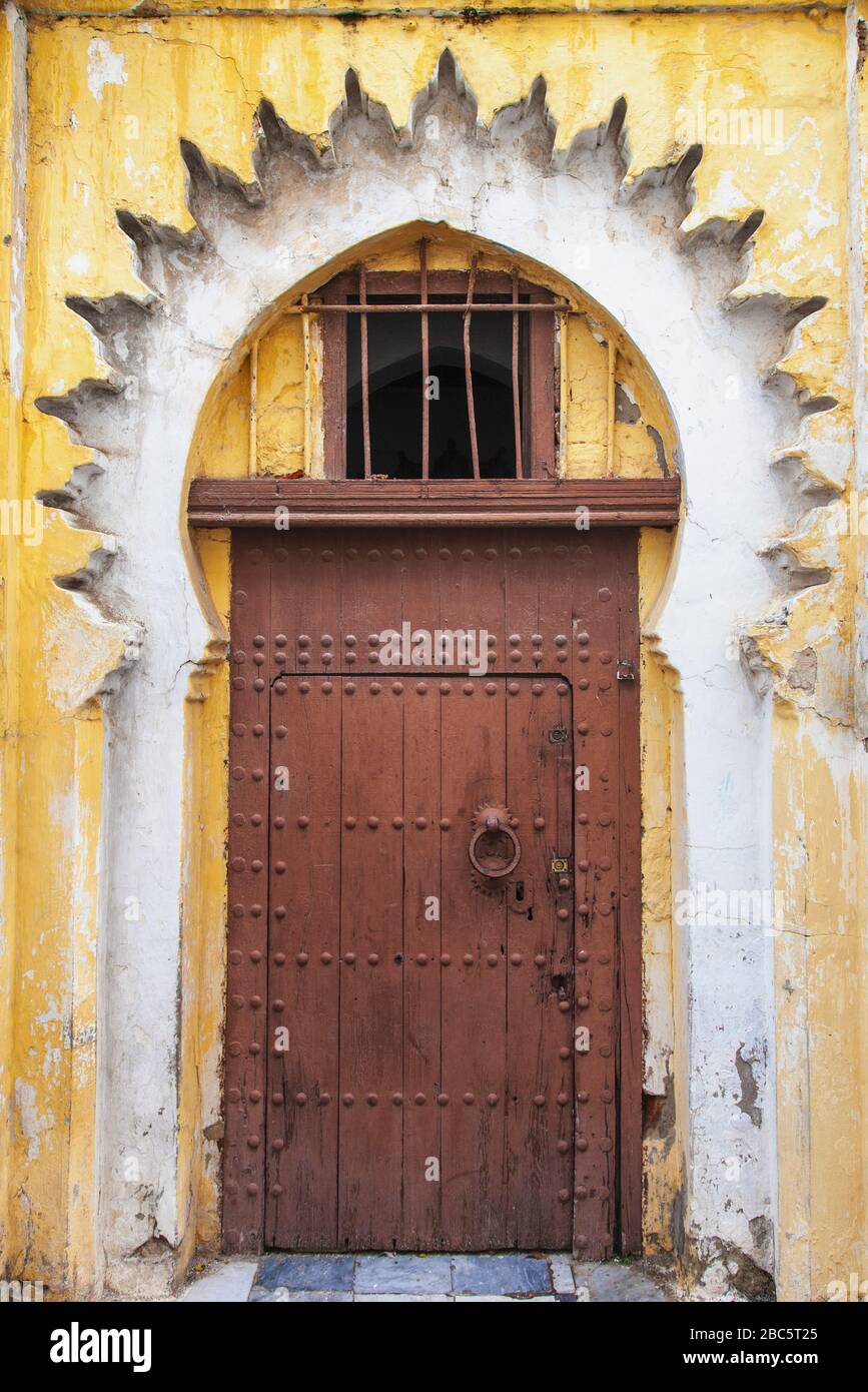 Antigua puerta oriental en un edificio amarillo en Tánger, Marruecos, África Foto de stock