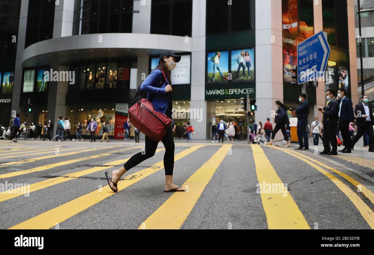 Hong Kong, CHINA. 3 de abril de 2020. Mujer enmascarada cruzando la cebra en el centro financiero en Central a mediodía. Según LA OMS, las infecciones por coronavirus están llegando a casi 1 millón en todo el mundo, sin señales de disipación.April-3, 2020 Hong Kong.ZUMA/Liau Chung-ren crédito: Liau Chung-ren/ZUMA Wire/Alamy Live News Foto de stock
