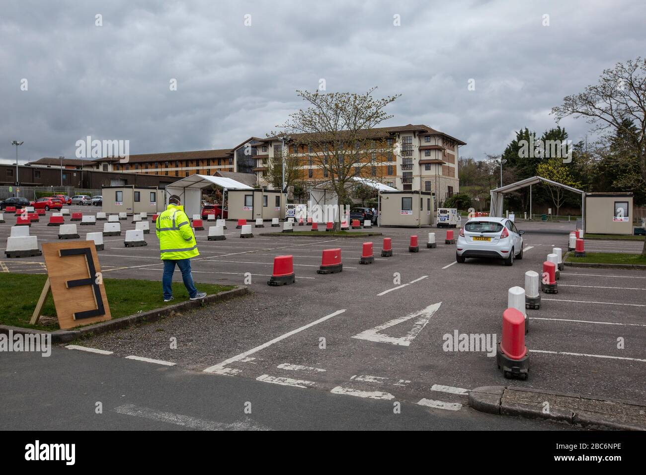 Chessington World of Adventures, Surrey, Reino Unido. 2 de abril de 2020. La seguridad de SERCO espera para el personal de NHS en los coches que se muestran en cola para ser probado para coronavirus en una facilitiy de conducción en Chessington World of Adventures en Surrey. 02 de abril de 2020. Hoy, el Gobierno del Reino Unido anuncia que se dirige a 100,000 pruebas de coronavirus al día después de anunciar un plan de pruebas de cinco puntos en todo el país. Crédito: Jeff Gilbert/Alamy Live News Foto de stock