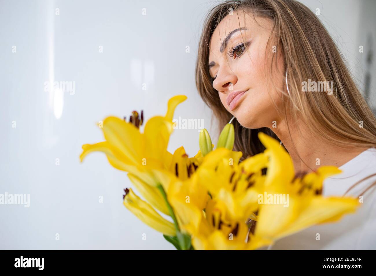 Chica enamorada, joven y en forma, hermosa mujer con una flor amarilla - narciso. Postura romántica Fotografía de stock - Alamy Chica enamorada, joven y en forma, hermosa mujer con una flor amarilla - narciso. Postura romántica Fotografía de stock - Alamy