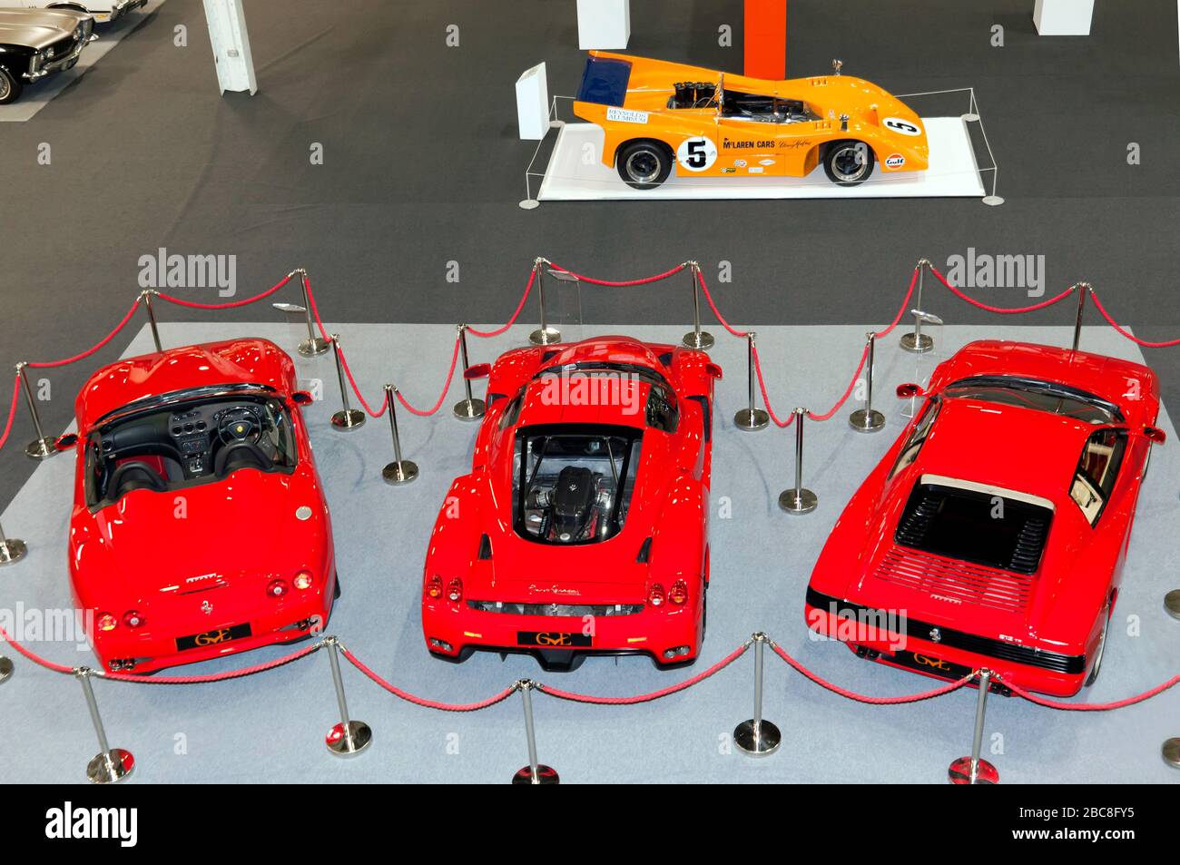 Vista aérea de tres Ferraris rojos (de izquierda a derecha: Testarossa, Enzo y un Ferrari 550 Barchetta), y un McLaren M8D, en exhibición en el London Classic Car Show 2020 Foto de stock