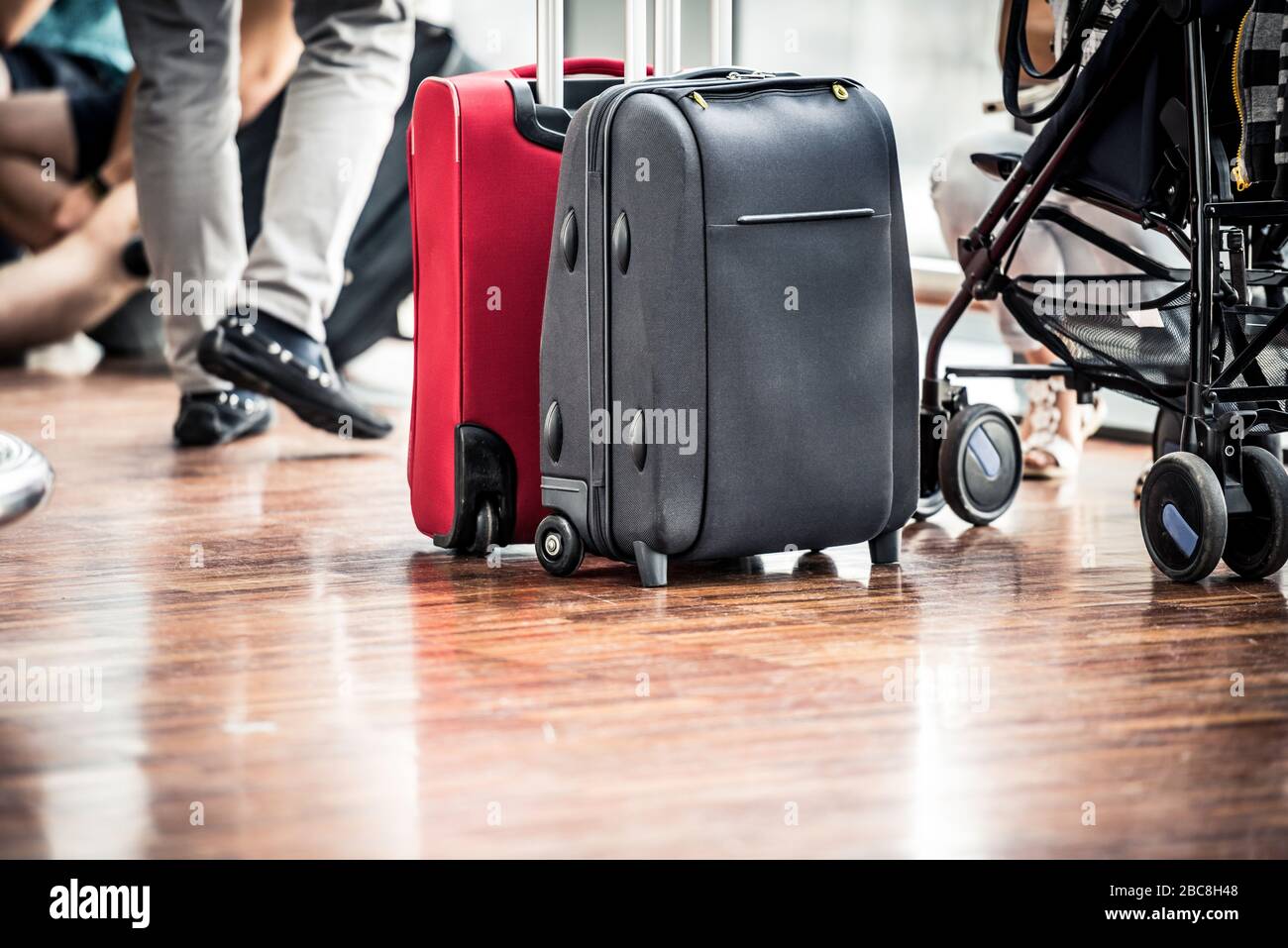 Viajeros con maletas en el aeropuerto. Primer plano de dos maletas para  pasajeros y un cochecito para bebés en un aeropuerto Fotografía de stock -  Alamy