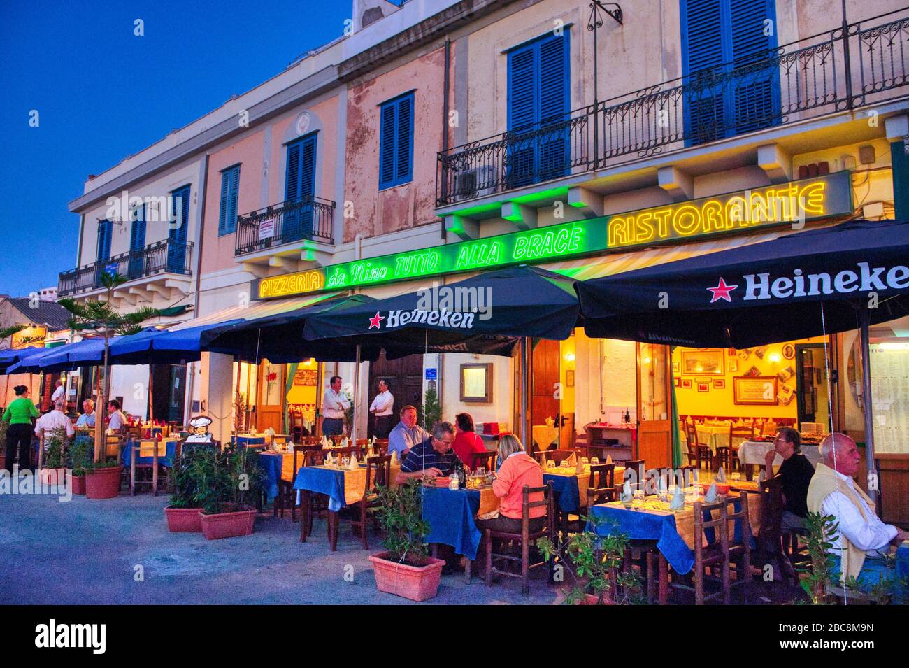 Gente comiendo y bebiendo en bares en Cefalu, Italia Foto de stock