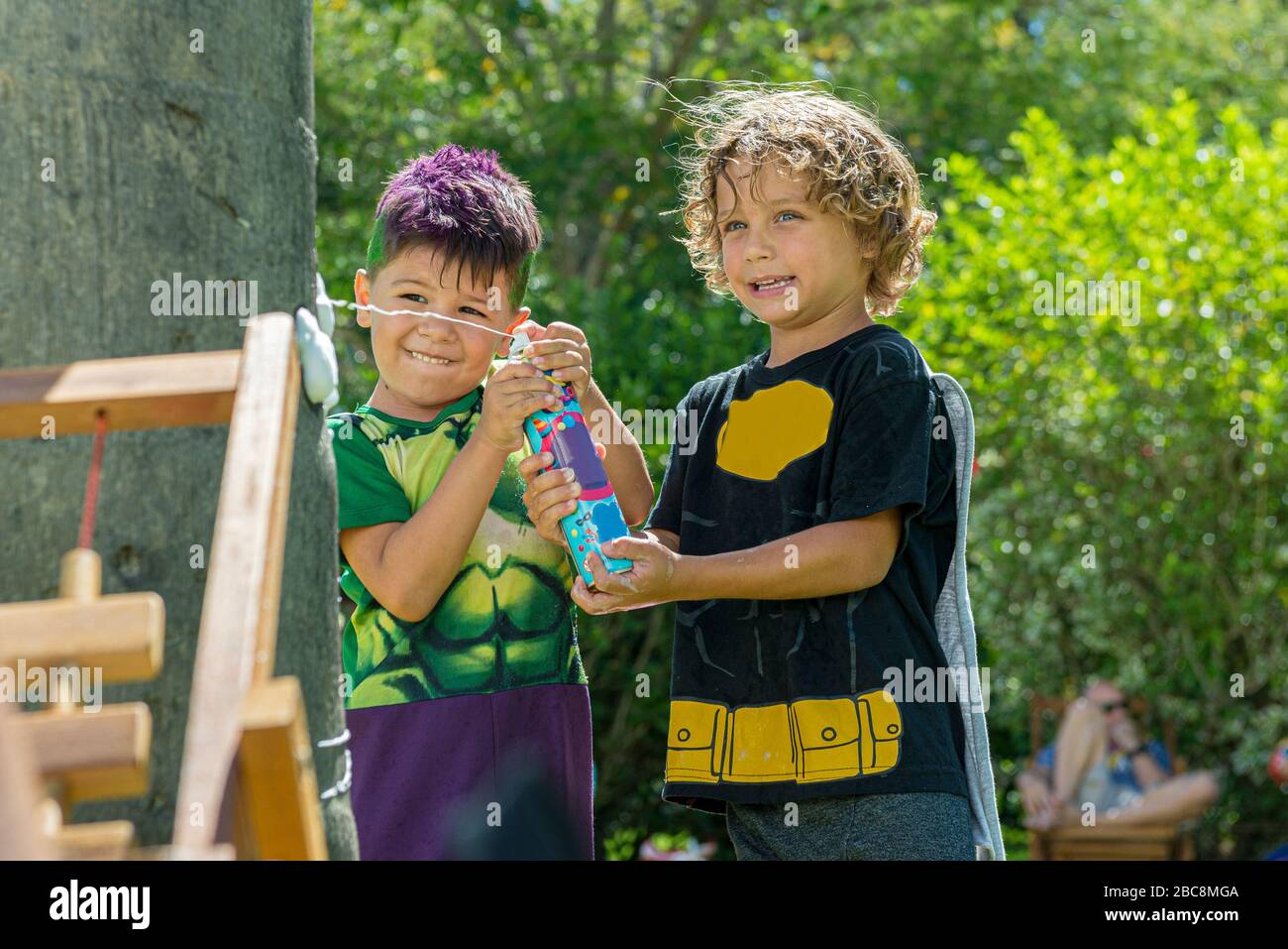 Dos hermosos chicos caucásicos divertirse con una lata de espuma en el  carnaval al aire libre en un hermoso día soleado. Niños disfrazados para la  fiesta de carnaval Fotografía de stock -
