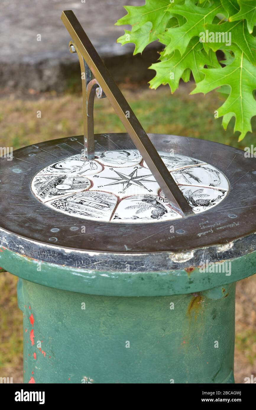 Reloj solar de latón vintage sobre poste cilíndrico de metal fundido verde  Fotografía de stock - Alamy