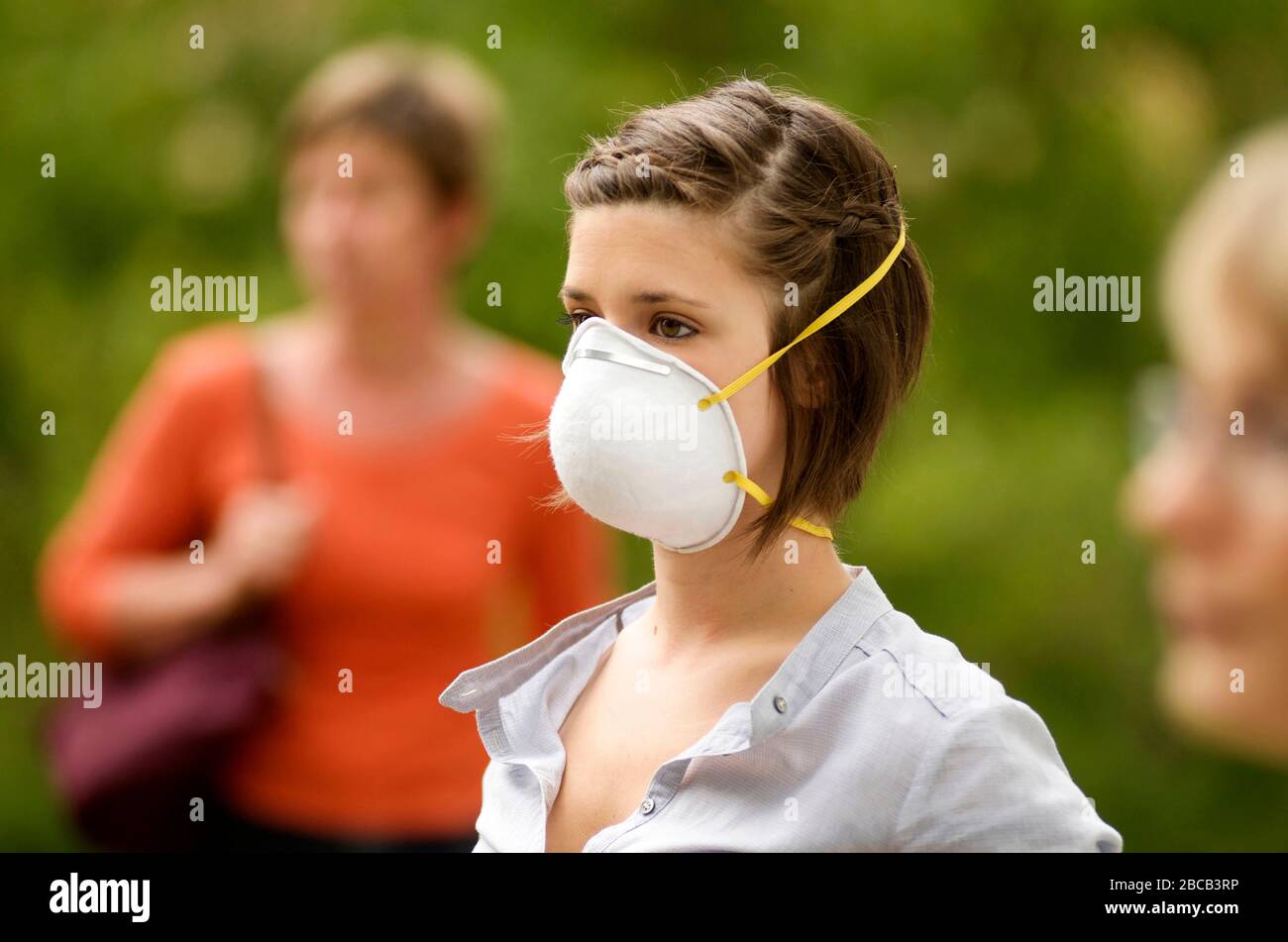 Primer plano de una máscara de coronavirus usada por una mujer joven Foto de stock