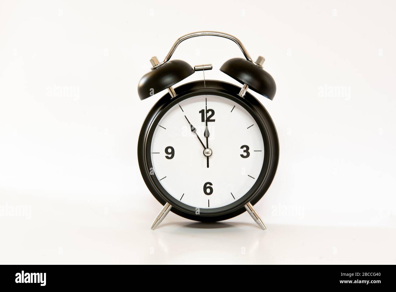 Reloj despertador clásico con diseño sencillo y minimalista, aislado sobre  fondo blanco. de 5 a 12 horas al mediodía/medianoche Fotografía de stock -  Alamy