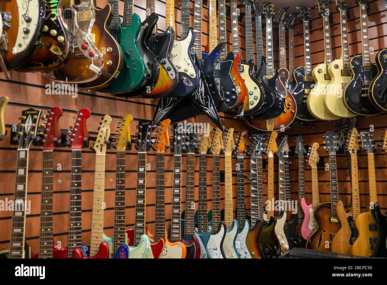 Moscú - 15 de noviembre de 2019: Diferentes guitarras eléctricas cuelgan en  la tienda de instrumentos musicales a la venta Fotografía de stock - Alamy