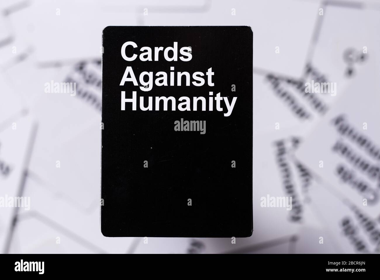 Cartas contra la humanidad baraja apilada en la parte superior de otras  cartas blancas en el fondo. Tarjetas de fondo legibles Fotografía de stock  - Alamy