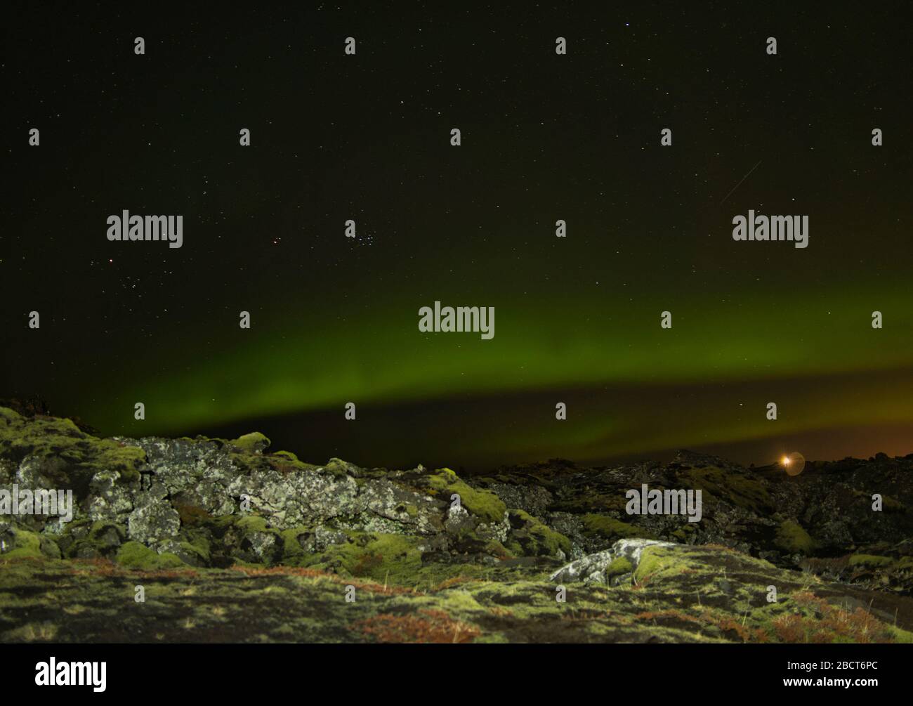 Luces verdes del norte sobre un paisaje rocoso en Islandia Foto de stock