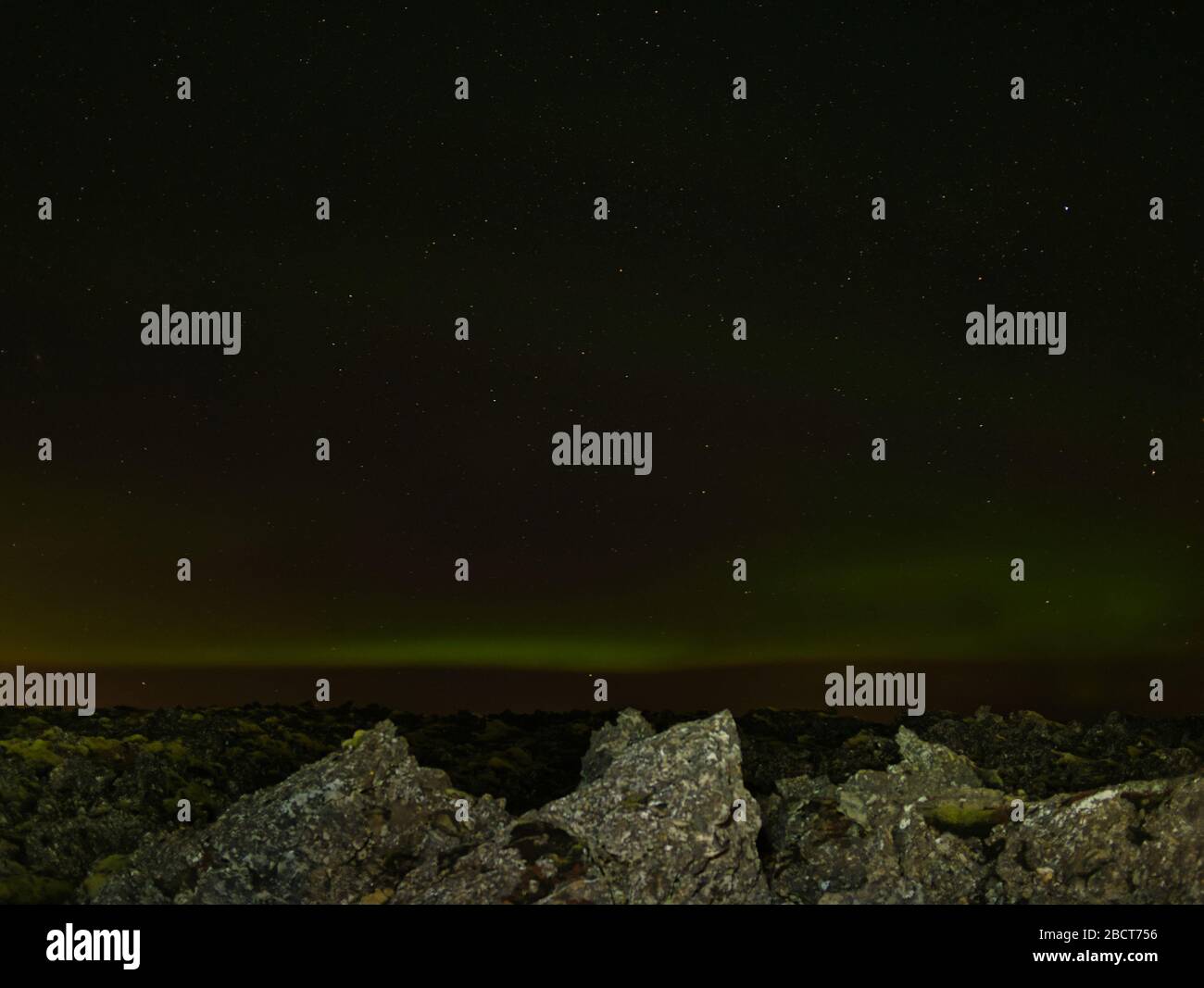Estrellas y luces verdes del norte sobre un campo de lava en Islandia Foto de stock