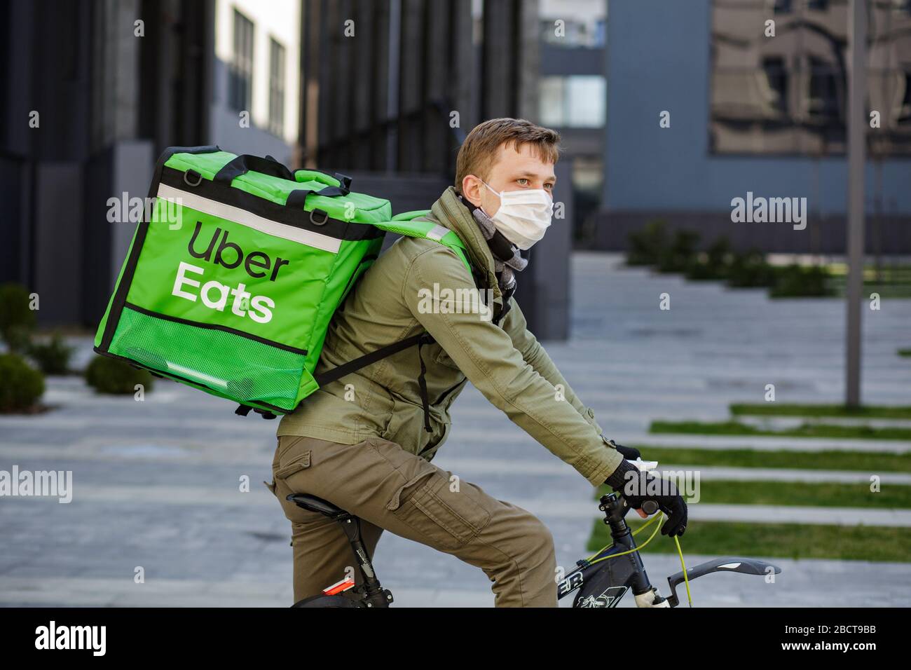 Proveedor de alimentos con mochila Uber Eats montando una bicicleta en el  plato Fotografía de stock - Alamy