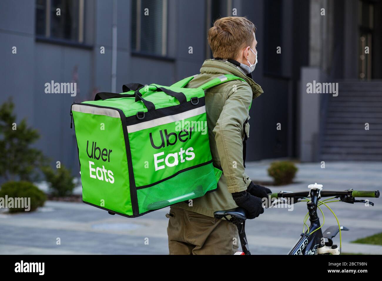 Proveedor de alimentos con mochila Uber Eats montando una bicicleta en el  plato Fotografía de stock - Alamy