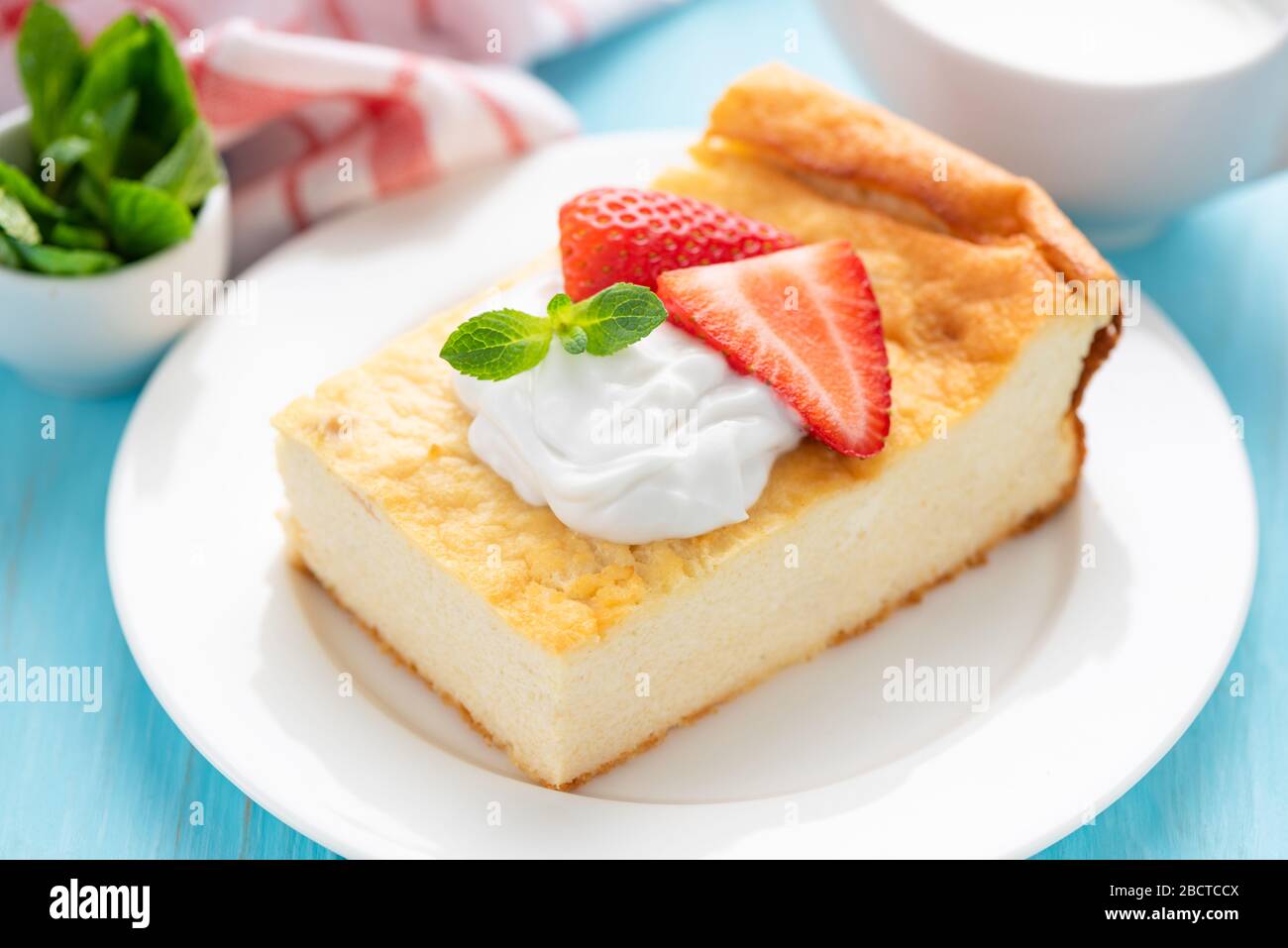 Sabrosa cazuela de queso cottage con crema y fresas en plato blanco. Tarta de queso casera perfecta para el desayuno o el aperitivo Foto de stock