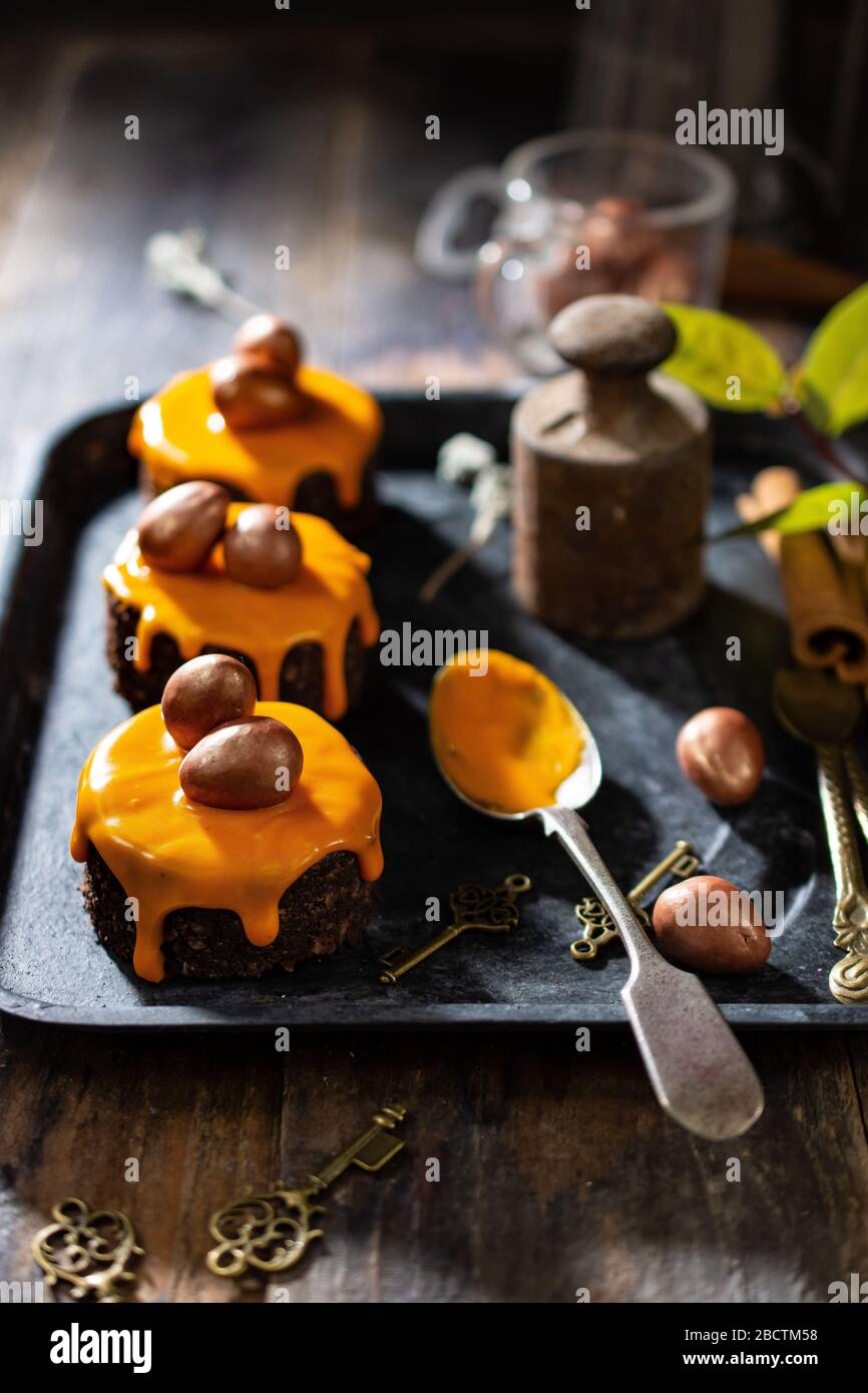 Pastelitos de Pascua cubiertos de hielo y decorados con huevos de chocolate. Comida y bebida saludable Foto de stock