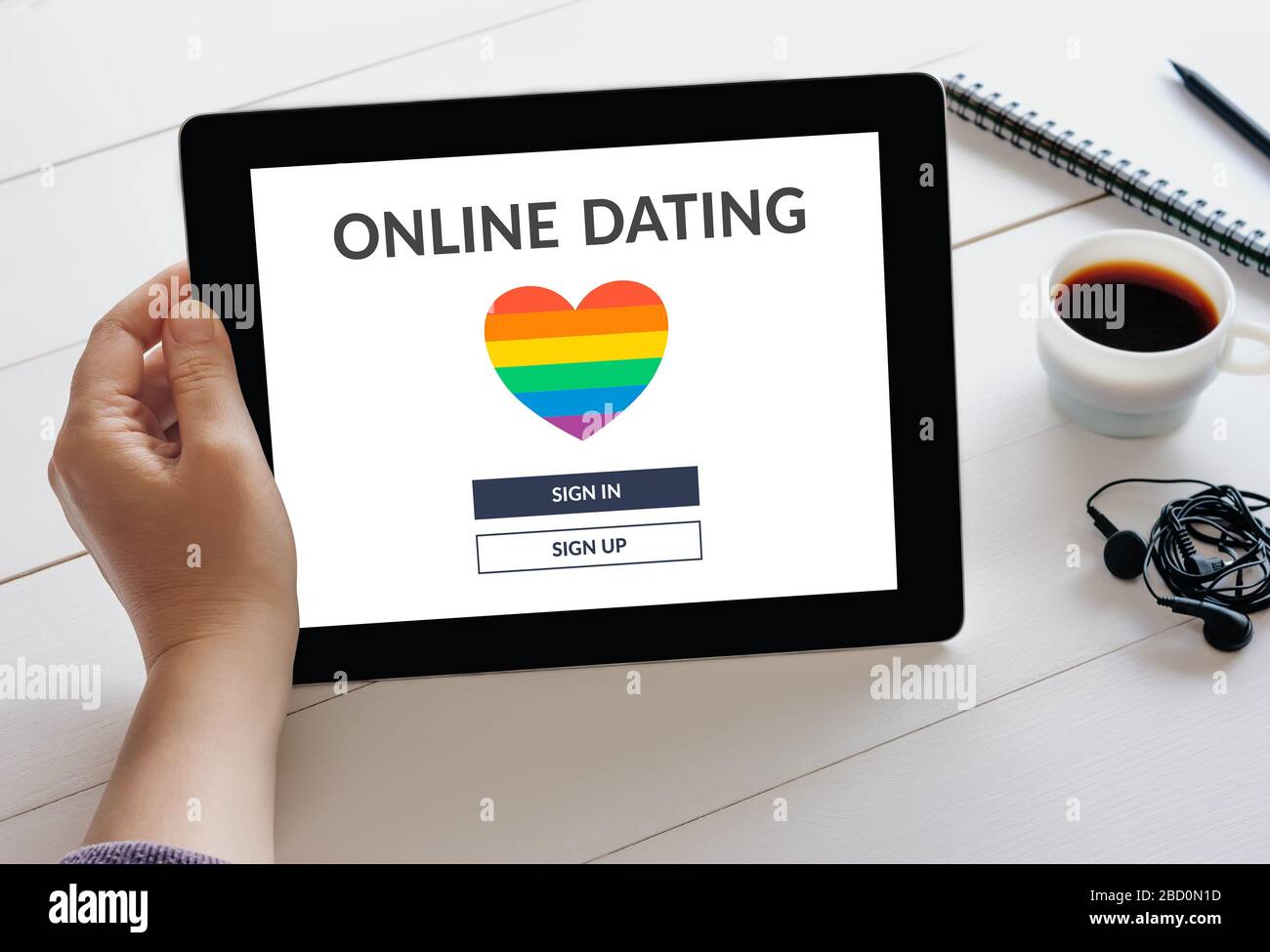 Mano de la mano de la tableta digital con LGBT fechar aplicación concepto en la pantalla. Gay citas en línea. Foto de stock