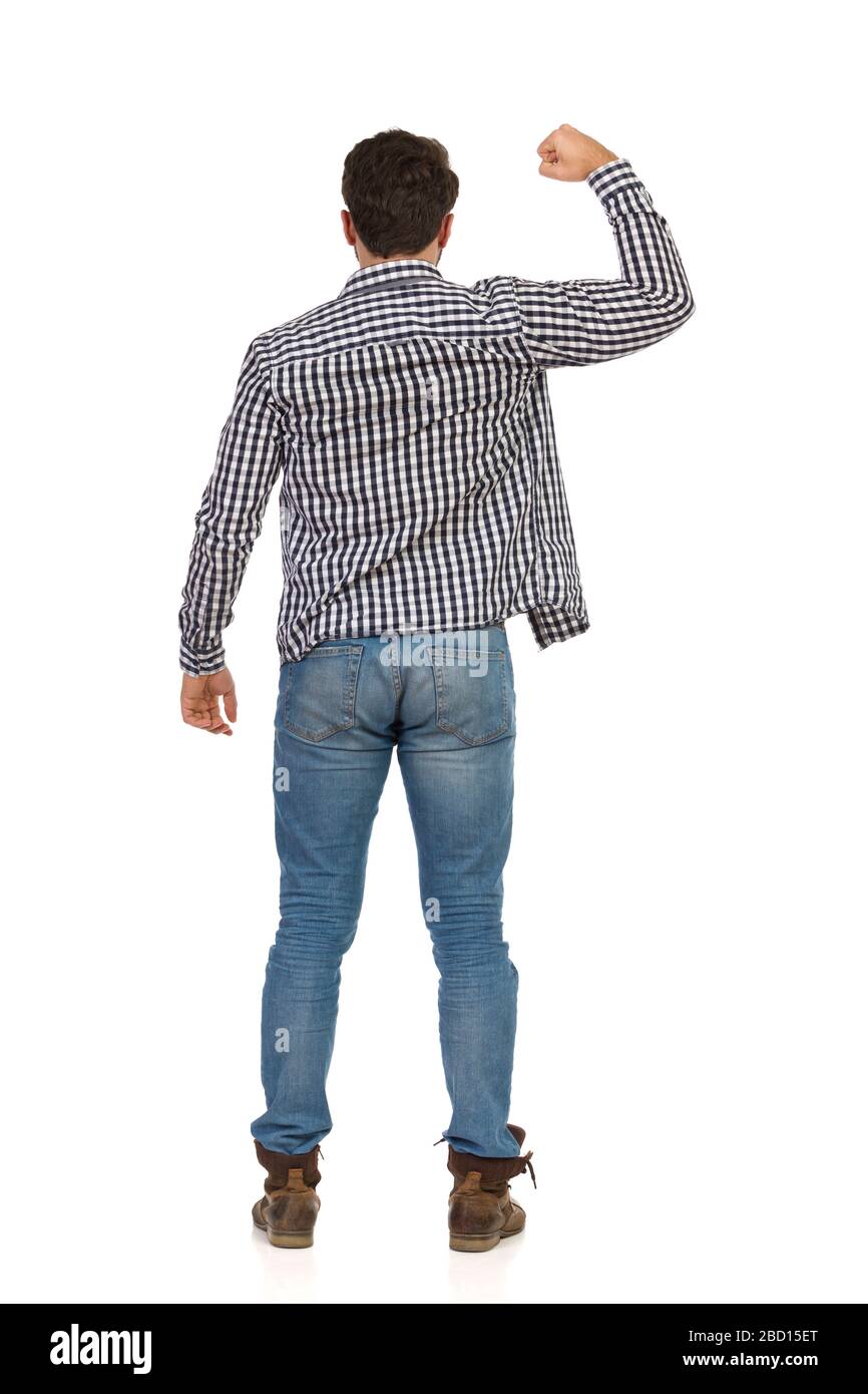 Hombre en jeans, botas y camisa de luberjack está de pie con el puño  levantado y flexionando los músculos. Vista trasera. Estudio completo  aislado sobre blanco Fotografía de stock - Alamy