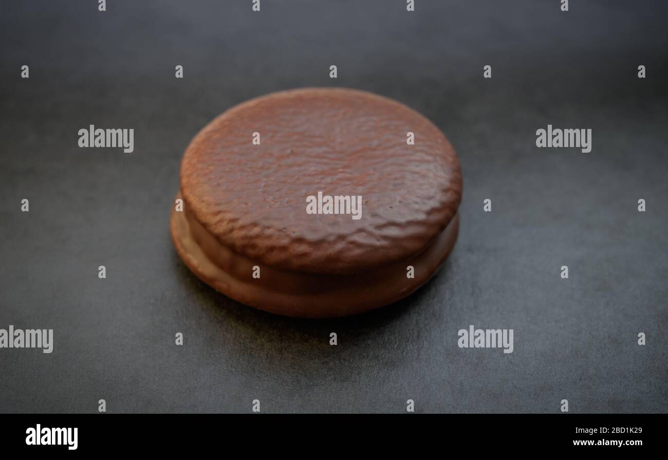 Galleta de chocolate sobre un fondo oscuro. Luz natural. Enfoque selectivo. Foto de stock