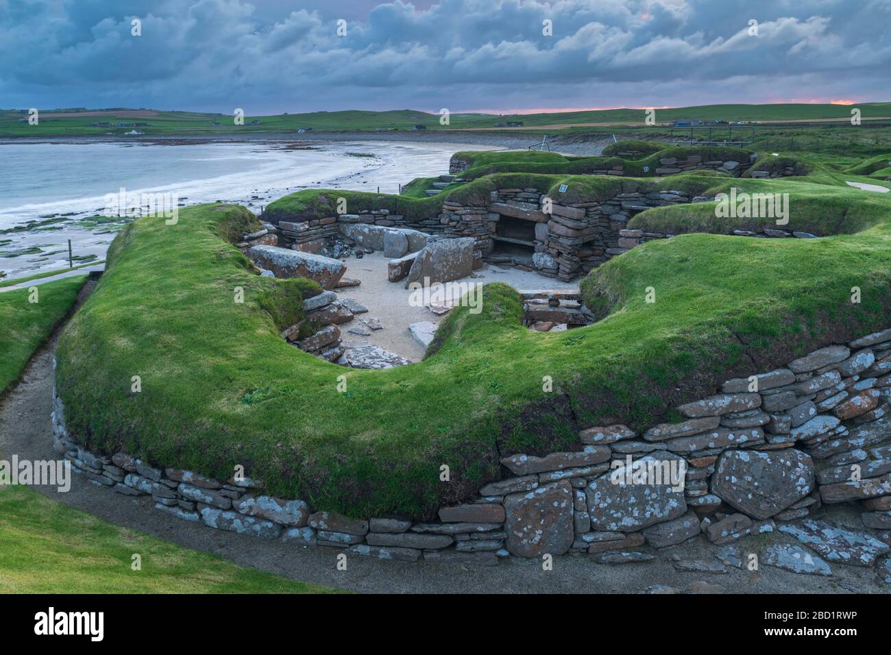 Cielo tormentoso sobre Skara Brae, Patrimonio de la Humanidad de la UNESSCO, un pueblo neolítico en el continente de Orkney, Escocia, Reino Unido, Europa Foto de stock