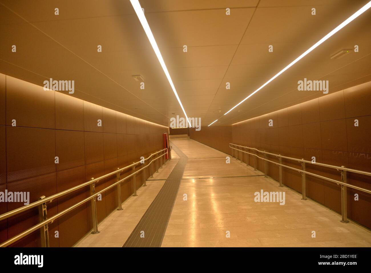 Túnel de conexión del metro por la noche con iluminación brillante Foto de stock