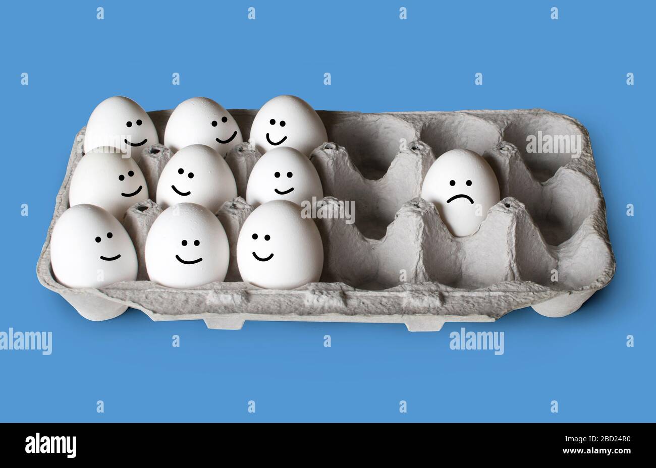 Huevos blancos en un cartón, uno separado de la multitud, concepto de distanciamiento social Foto de stock