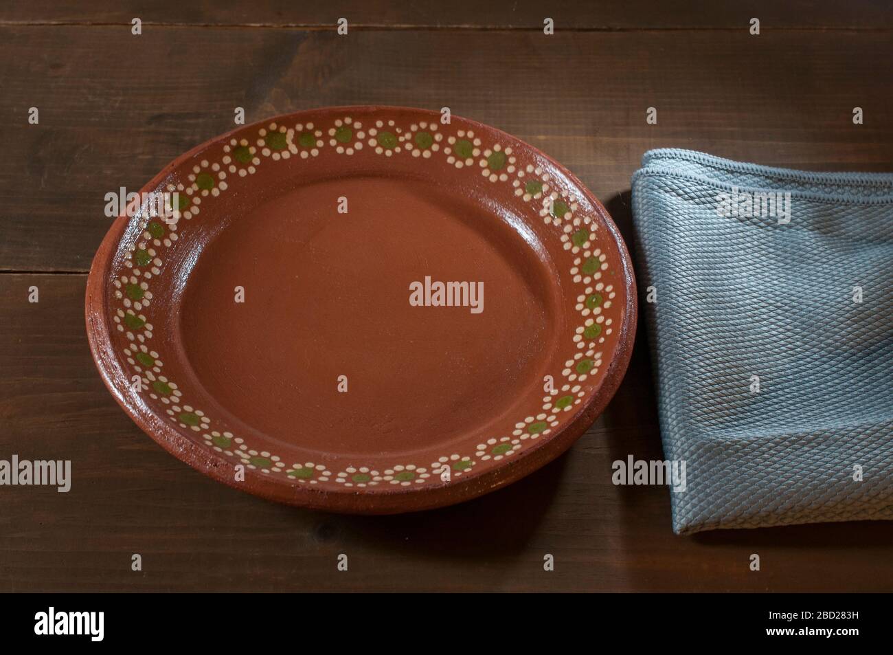 Plato mexicano hecho de barro o barro sobre una mesa rústica de madera y  una cultura de servilletas azules de México. Fotografía de la vida fija  Fotografía de stock - Alamy