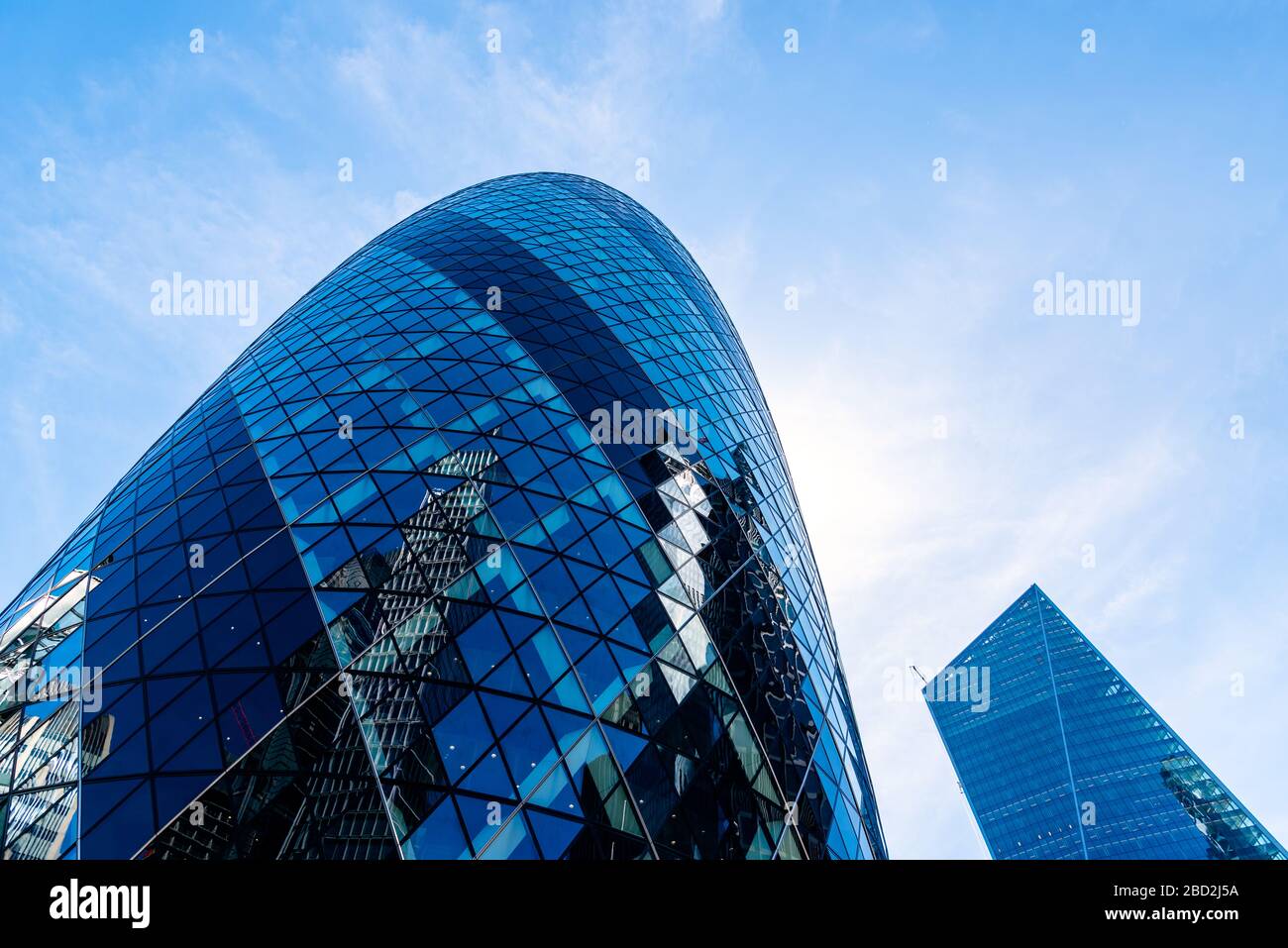 Londres, Reino Unido - 14 de mayo de 2019: Vista de bajo ángulo de los edificios de oficinas en la ciudad de Londres contra el cielo azul. 30 San María Ax o Gherkin Buiding por Norman Fost Foto de stock