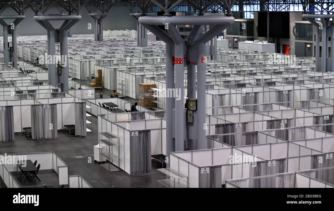 Cientos de camas de hospital cubren el piso en una estación médica federal COVID-19, centro de ayuda para la pandemia de coronavirus establecido en el Centro Jacob Javits el 30 de marzo de 2020 en la ciudad de Nueva York, Nueva York. Foto de stock