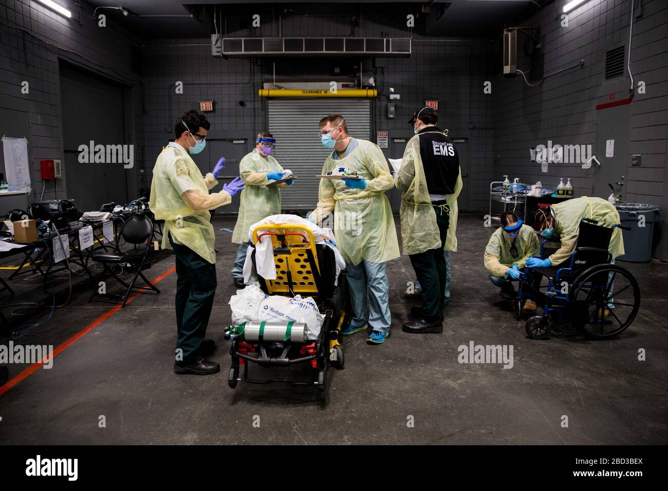 El personal médico del Ejército de los Estados Unidos realiza un chequeo para un paciente en la Estación médica Federal COVID-19, centro de ayuda para la pandemia de coronavirus establecido en el Centro Jacob Javits 5 de abril de 2020 en la ciudad de Nueva York, Nueva York. Foto de stock