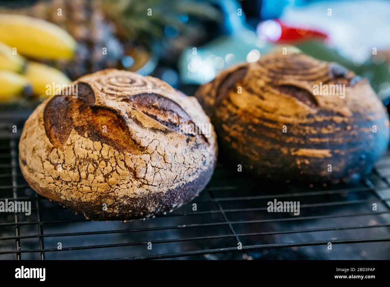 Panes de masa fermentada caseros que se refresca en los estantes de la encimera de la cocina Foto de stock