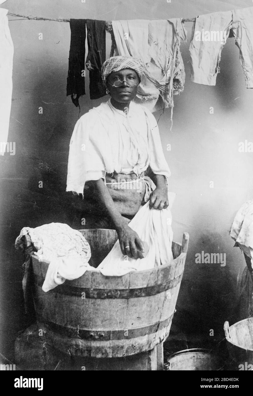 Mujer de la India occidental lavando ropa en una tina ca. 1910-1915  Fotografía de stock - Alamy