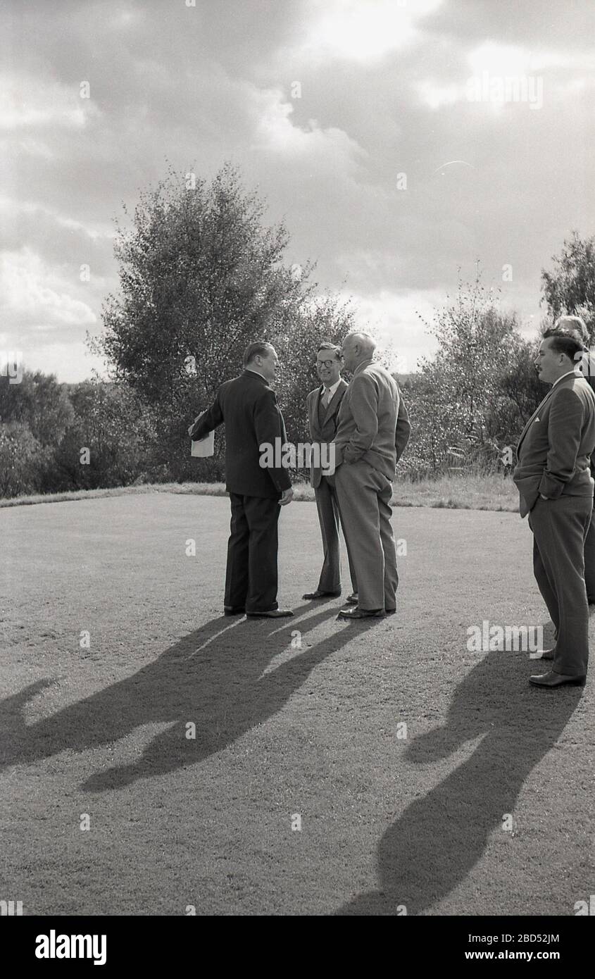 60, funcionarios históricos del golf, incluyendo el principiante charlando juntos en el primer tee en un torneo de aficionados, Inglaterra, Reino Unido. Foto de stock