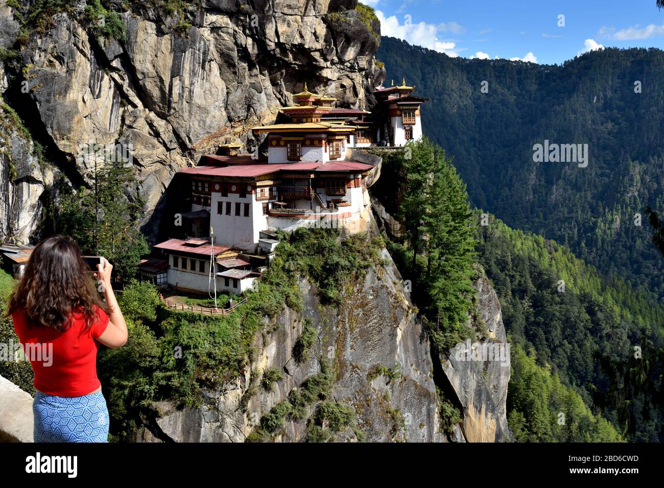 Un turista hace clic en una foto del paro Taktsang. Foto de stock