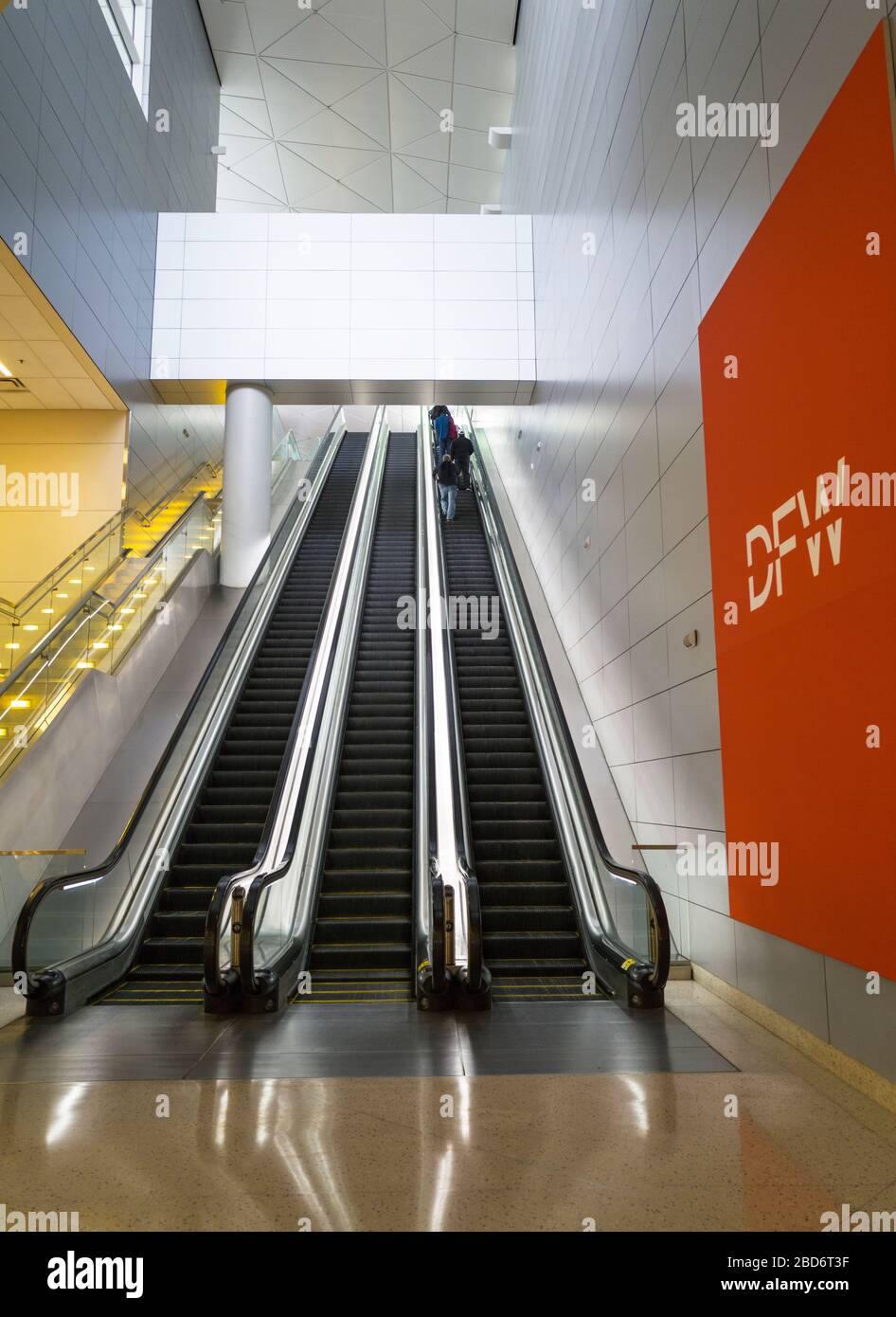 Pocos pasajeros en una escalera mecánica en el Aeropuerto Internacional Fort Worth de Dallas durante la pandemia de Coronavirus COVID-19, de lo contrario un aeropuerto muy concurrido. Foto de stock