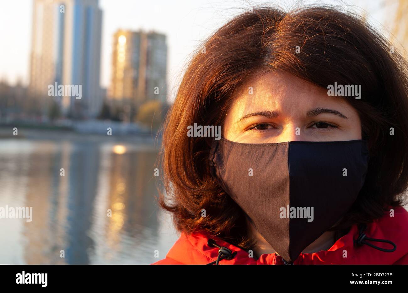 Retrato de una mujer con máscara de color negro hecha a mano. Cuarentena en el mundo en 2020. Prevención del brote de coronavirus SARS-CoV-2 Foto de stock