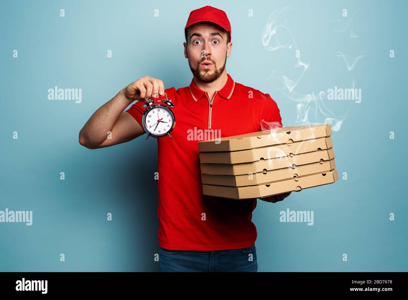 Courier es puntual para entregar rápidamente pizzas. Fondo cian Foto de stock