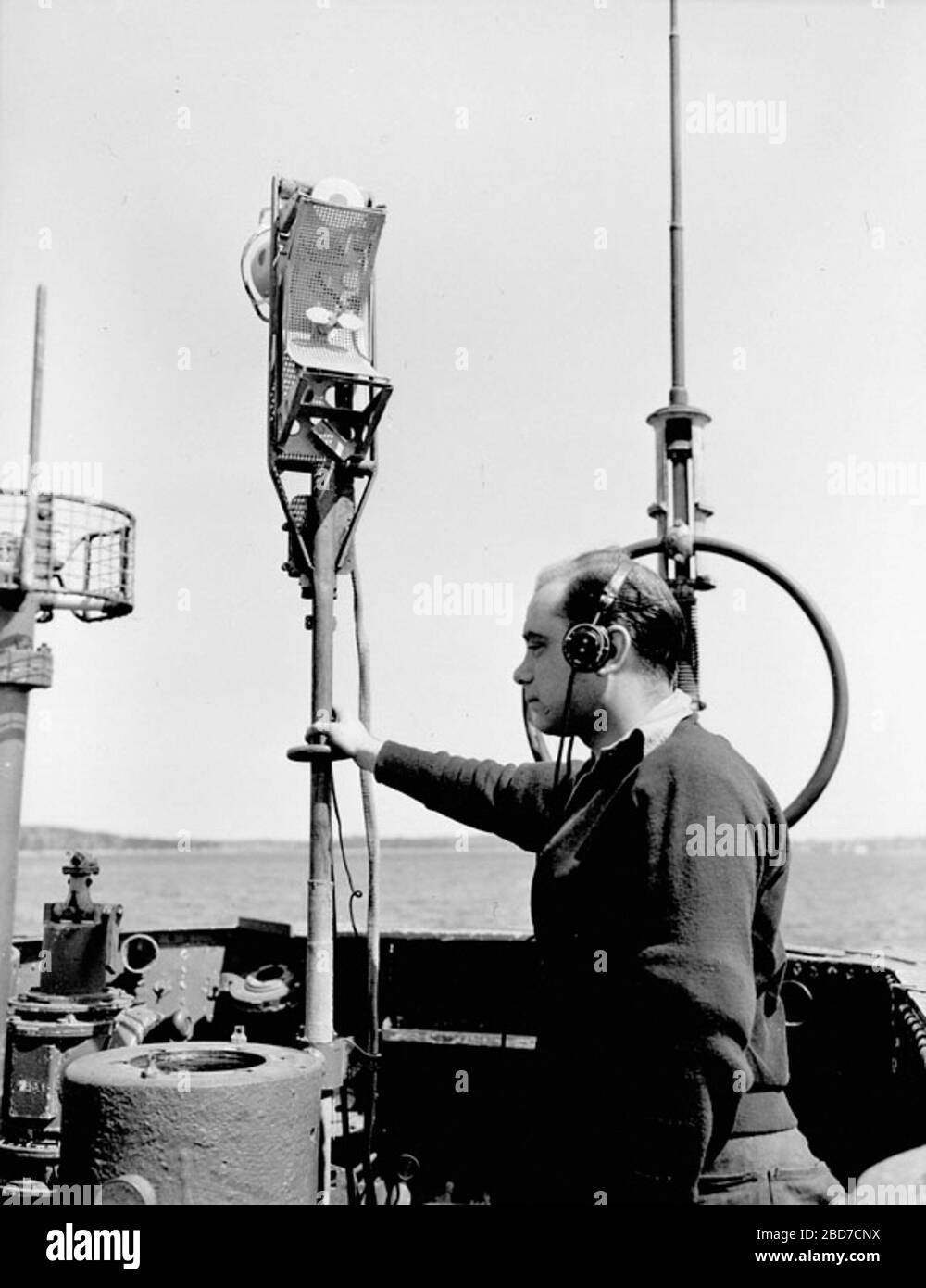 'Inglés: El submarino alemán U-889 se entregó a la Royal Canadian Navy el 13 de mayo de 1945 en Shelburne, Nueva Escocia, y fue llevado a Halifax. Esta imagen, tomada el 25 de mayo de 1945, muestra una calificación no identificada de la Marina Canadiense que examina el mástil de la antena del detector de radar de la U-889. Se trata de dos sistemas, el FuMB-7 Naxos sintonizado a las longitudes de onda de 9 cm utilizadas por el Reino Unido ASV Mk. Los radares III y H2S, y el FuMB-26 Tunis, sintonizados a las longitudes de onda de 3 cm utilizadas por los radares estadounidenses. En esta imagen la antena Naxos está mirando hacia la cámara, consiste en las dos antenas tipo hoja centradas en el reflector de malla parabólica sólo abo Foto de stock