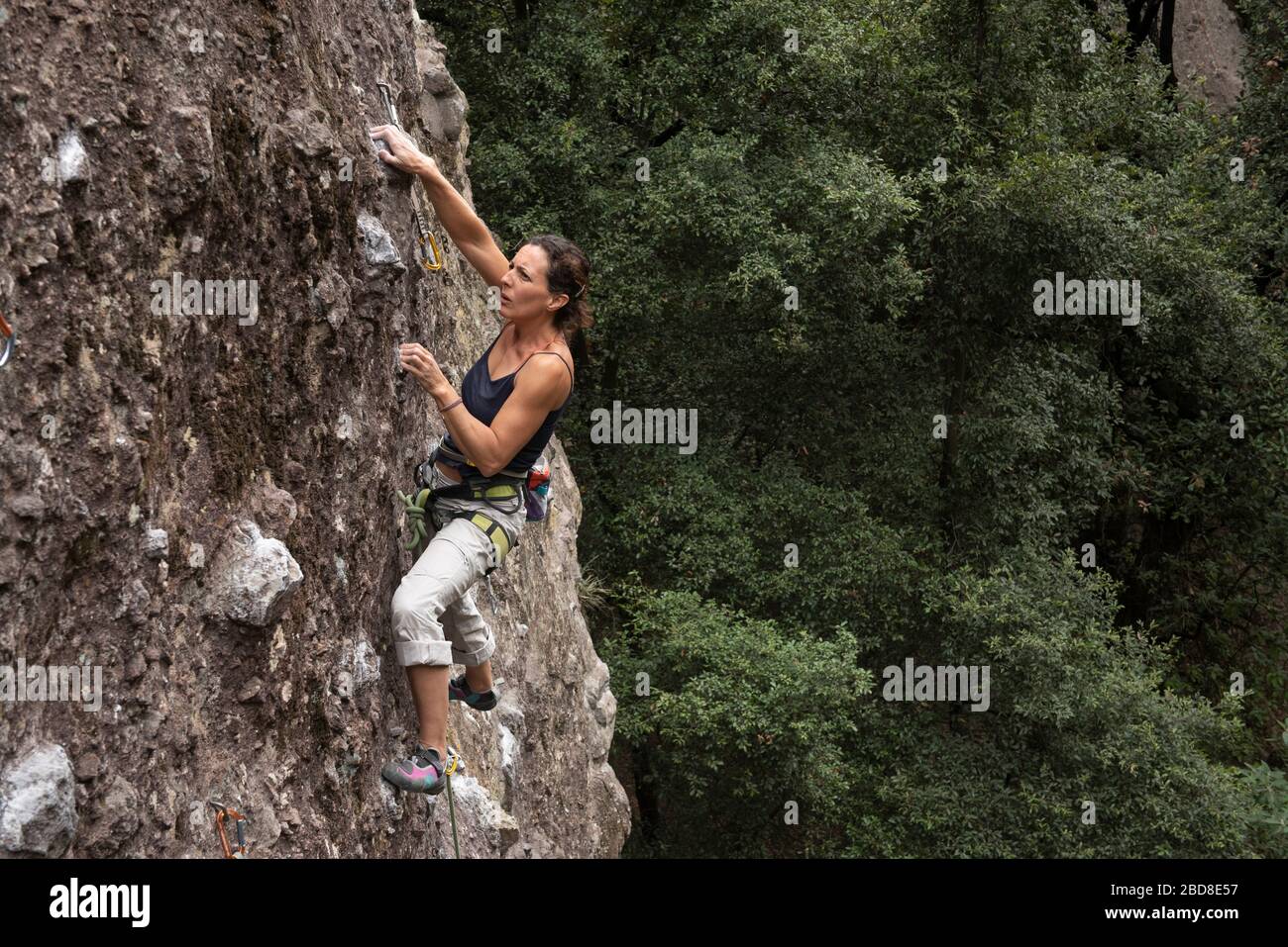 Una mujer se concentra mientras se sube en roca en Jilotepec Foto de stock
