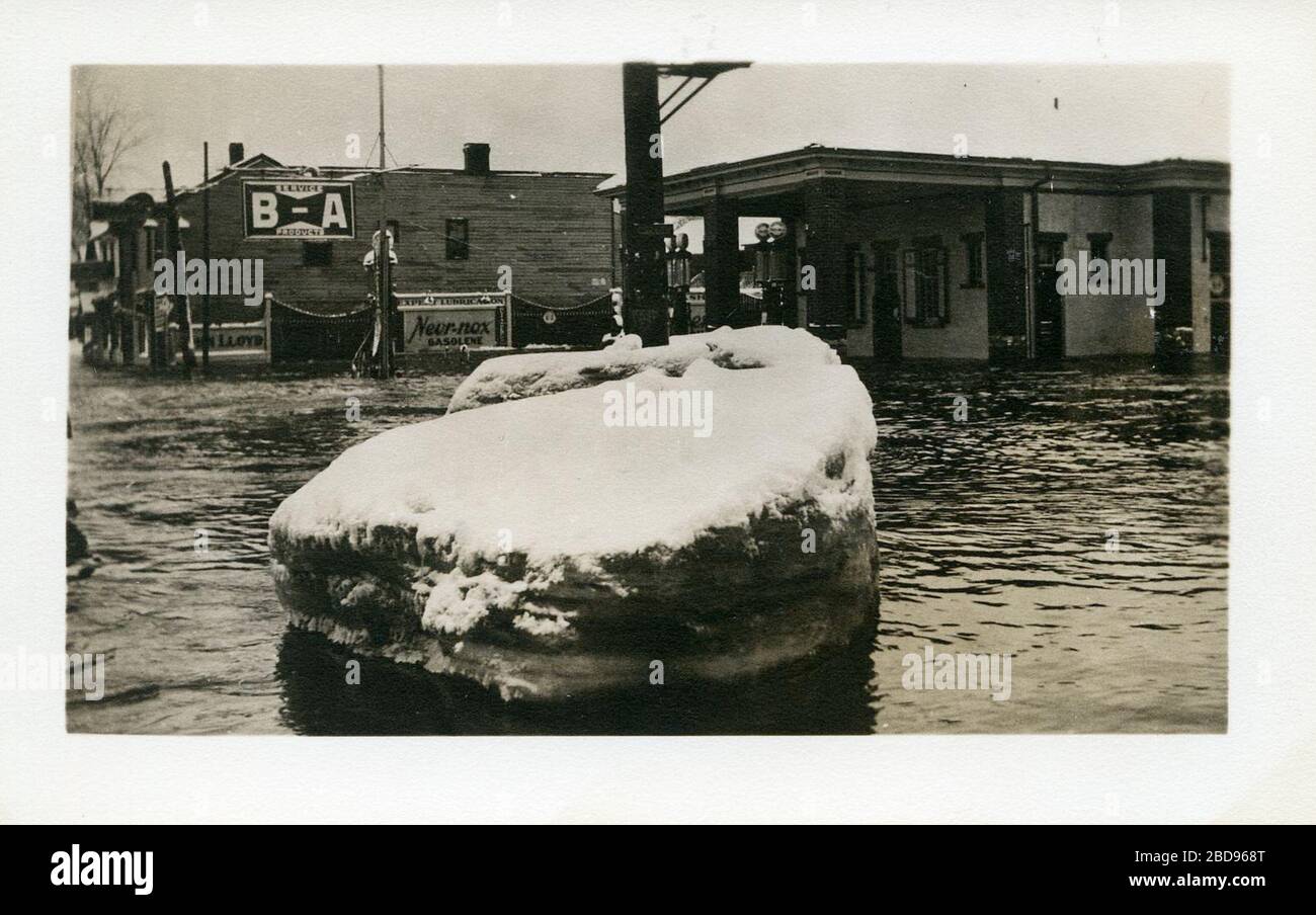 "Estación de gas inundada (Lloyd's en 10 Bridge Street West, Belleville, Ontario) con un gran trozo de hielo en el medio de la carretera. Este fue anteriormente el sitio del Hotel Windsor en la esquina noroeste de Coleman St. Y Bridge St. West.; 13 de marzo de 1936, 00:00; HC02975; Archivos de la Comunidad; ' Foto de stock