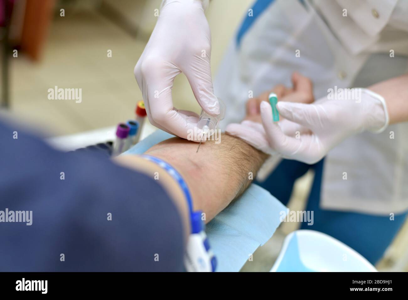 Proceso de toma de sangre venosa a través de una aguja para su análisis en un paciente de un enfermero de procedimiento médico masculino. Foto de stock