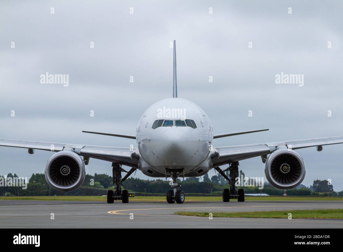 La vista frontal perfectamente circular de un Boeing 777-200ER cuando se apaga una vía de taxis hacia la terminal Foto de stock