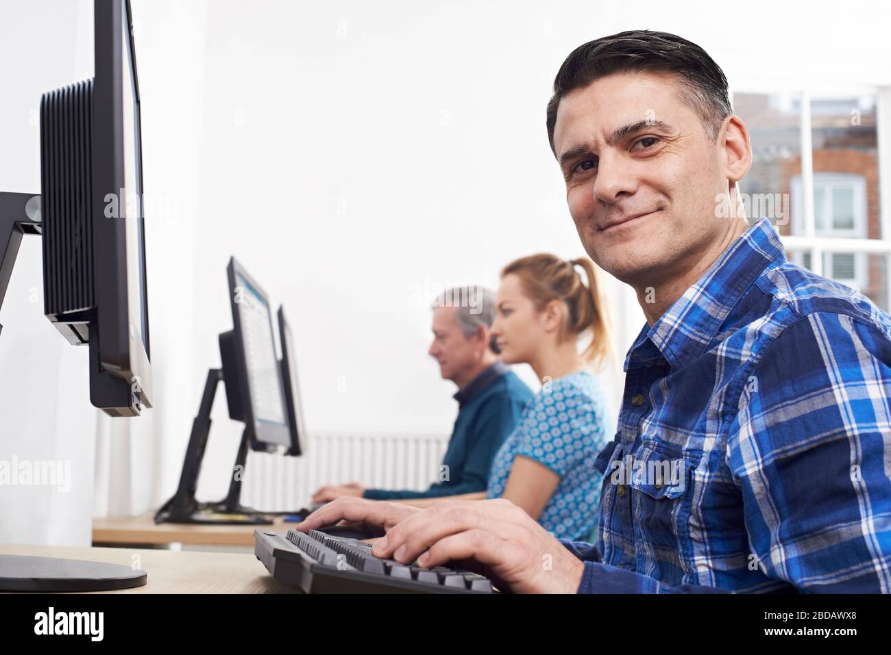 Retrato de un hombre maduro que asiste a una clase de computadora para adultos Foto de stock