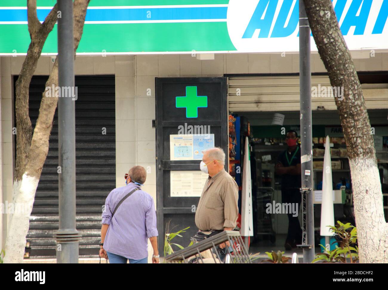 Caracas, Venezuela 31 de marzo de 2020: Personas en una calle casi vacía usando máscaras frente a una farmacia durante la propagación de la cubierta-19 Foto de stock