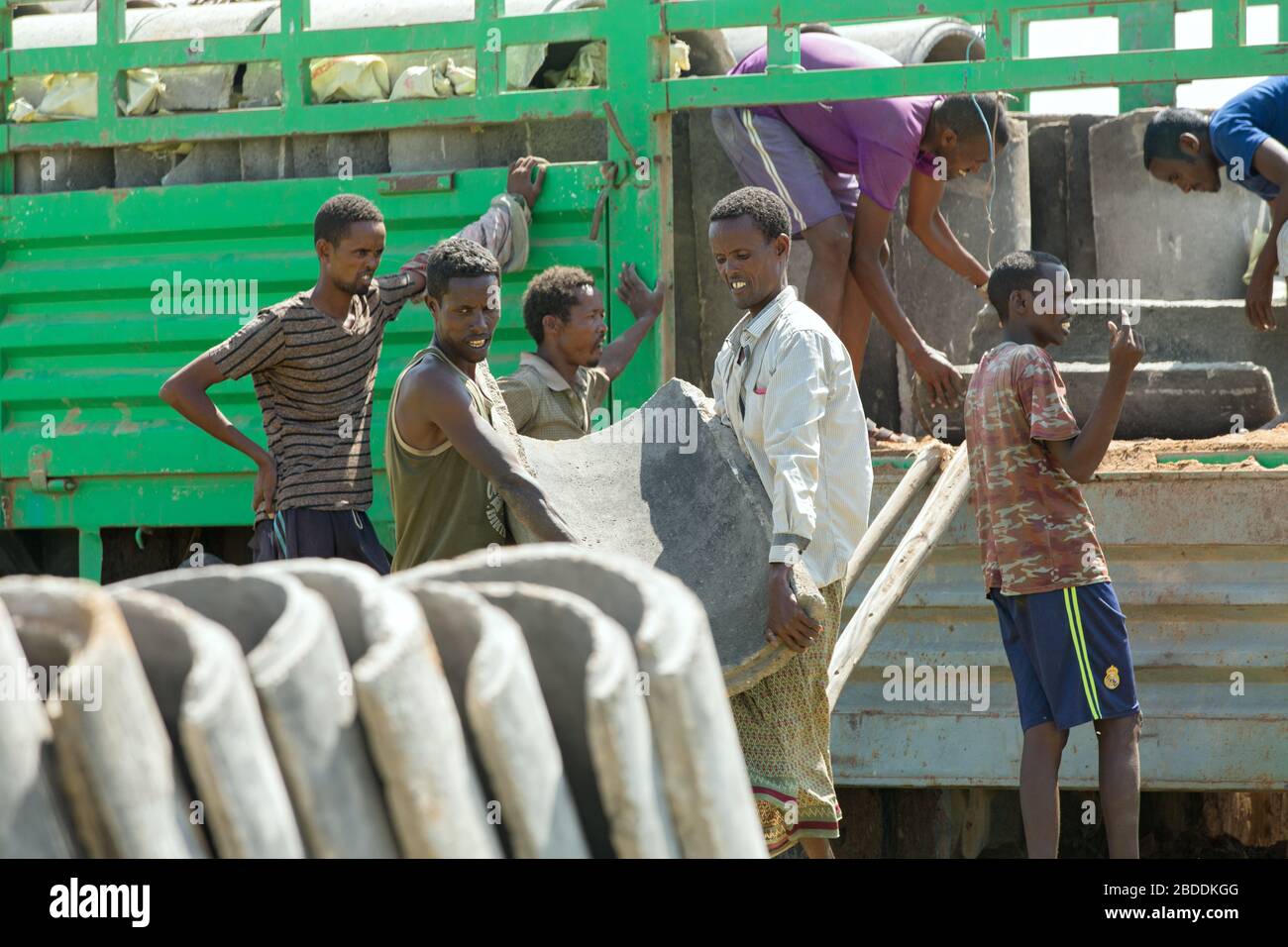 14.11.2019, Gode, Región Somalí, Etiopía - los trabajadores de la construcción descargan tuberías de agua de hormigón para el suministro de agua potable de la aldea Burferedo fr Foto de stock