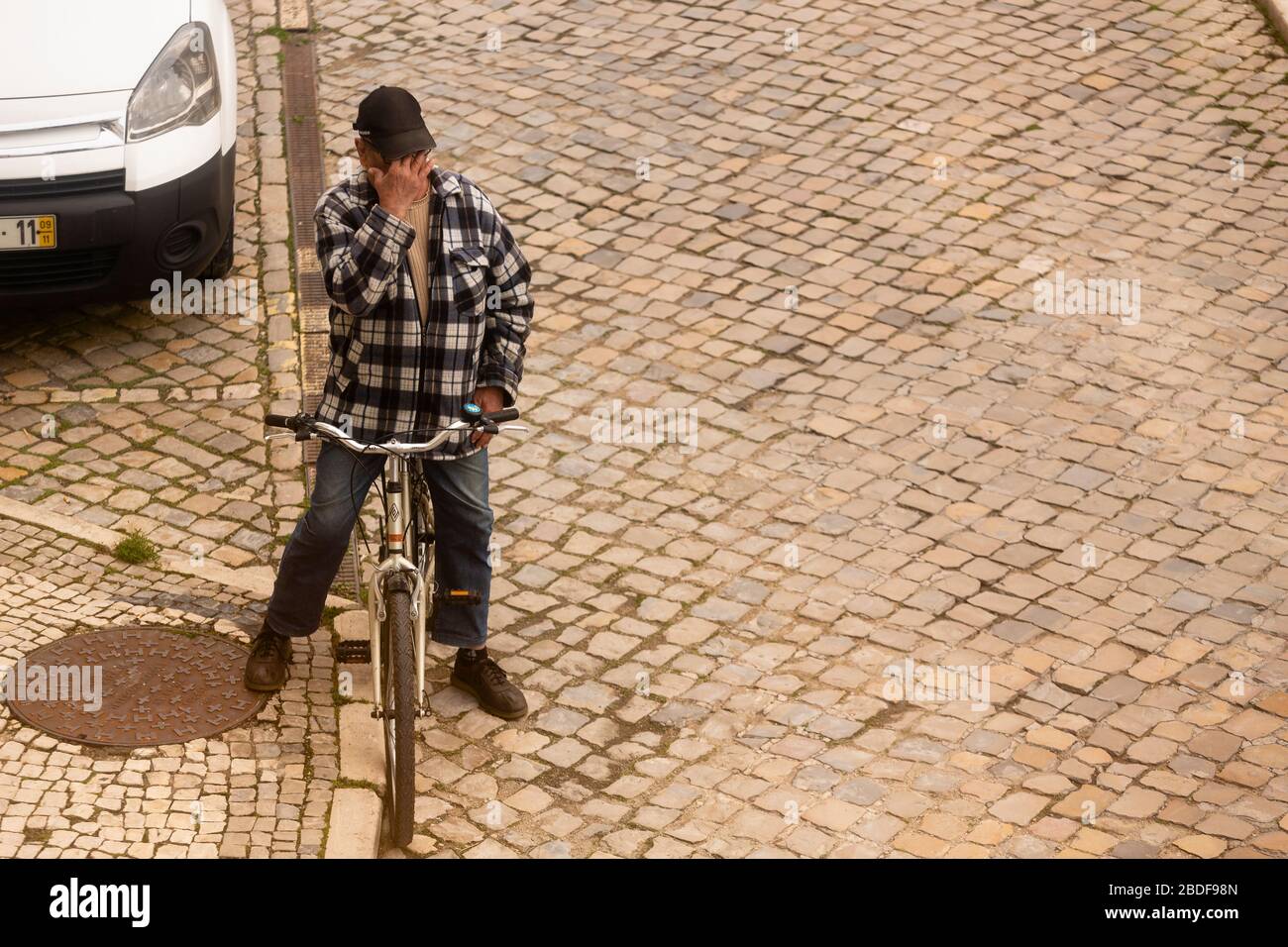 Olhão, Portugal, 8 de abril de 2020. Un hombre orando delante de la iglesia, con las calles prácticamente desiertas, como resultado del brote del Coro Foto de stock